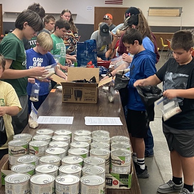 4-H members participate in a service project packing meals for those in need.