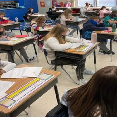 Students takes time to write their pen pals (seniors) in the classroom